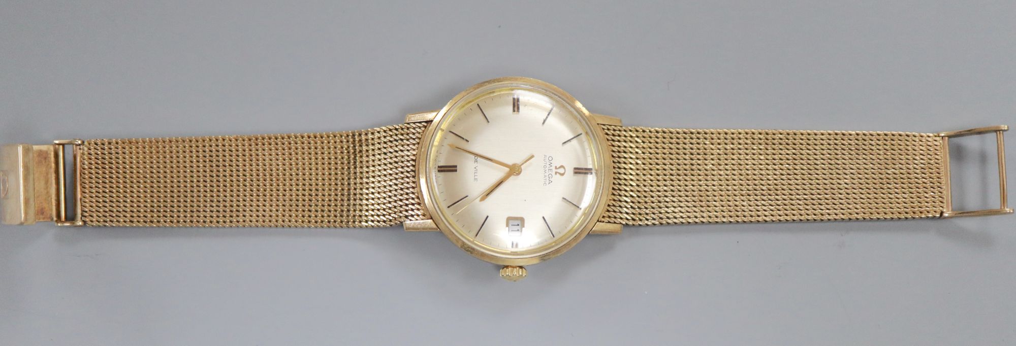 A gentlemans early 1970s 9ct gold Omega De Ville automatic wrist watch, on integral Omega 9ct gold bracelet,